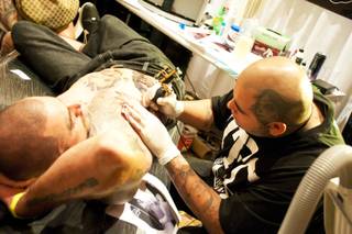 Fernie Andrade, right, of Los Angeles works on Brandon Mladinich at the 2011 Biggest Tattoo Show on Earth at the Mirage on Friday, Sept. 30, 2011.